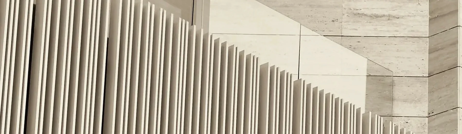Aluminium fins meeting travertine coursing