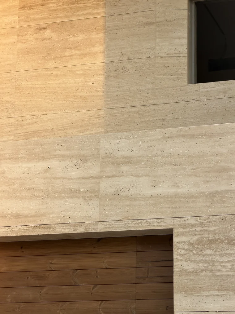 Villa Louve under construction — travertine coursing above the timber gate