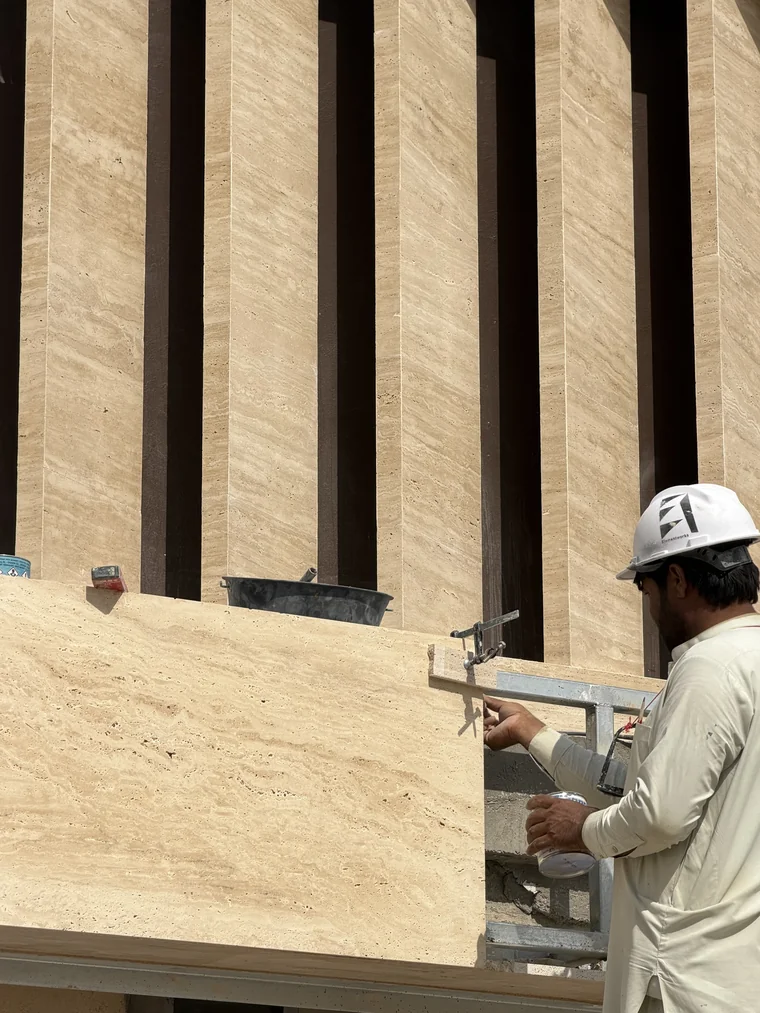 ELEMENTWORKS installer setting a travertine panel on its fixing bracket